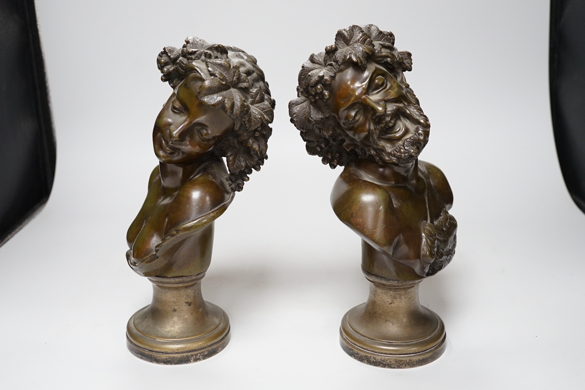 A pair of late 19th century French bronze Bacchic busts, on plated socles, 28cm